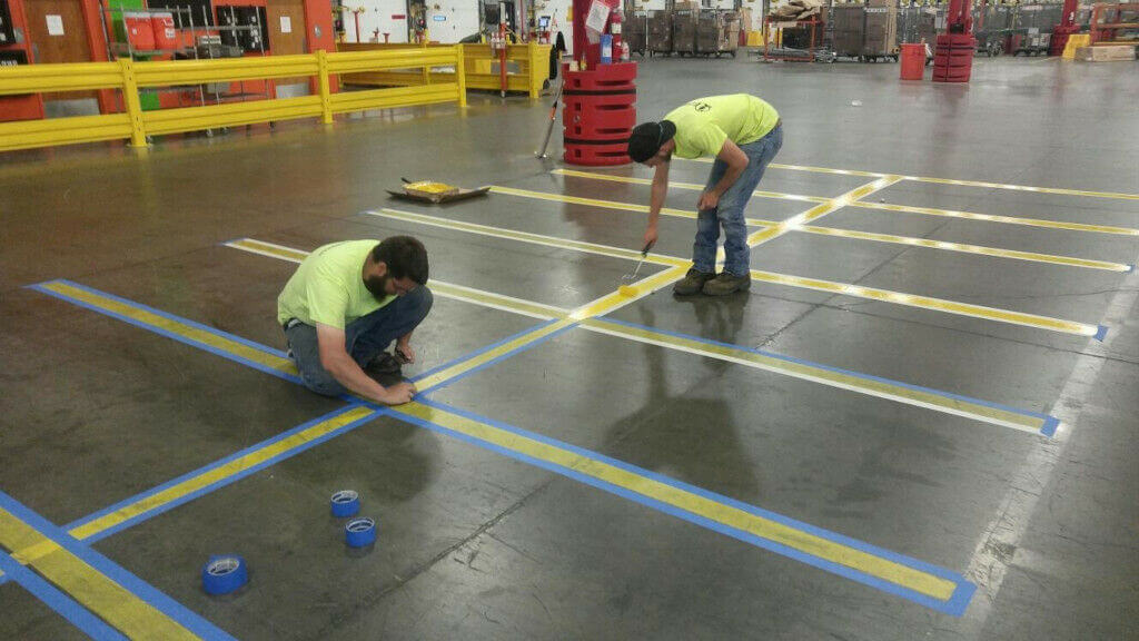 Evercor workers painting warehouse floor lines